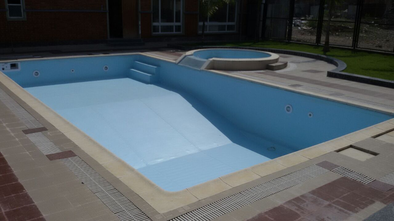 Pool construction stage 5: the empty pool with a blue interior finish, entry steps, coping and deck drainage.