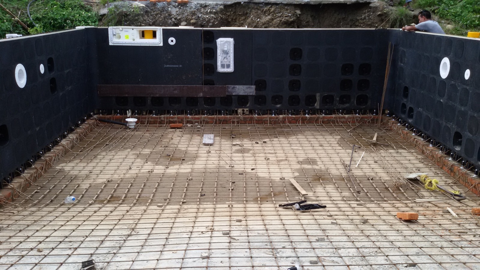Pool construction stage 4: steel reinforcement across the pool floor with wall panels and fittings in position.